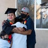 Jacqueline Hernandez Rico, 33, gets a hug from her sons Eric Salvador Hernandez, 11, Ivan Santiago Hernandez, 6, and husband Irvyn Hernandez while watching the virtual Raza Grad ceremony on June 13, 2020 in Perris. (UCR/Stan Lim)