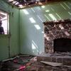 UCR researcher Todd Luce peers inside a room with a fireplace from a window in the Case residence.