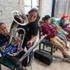 Andrea Nataly Luis Pérez leads young students in band practice.