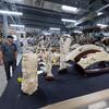 French stands near a table with an assortment of items made of ivory in the Morphology Center.
