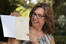 Roseanne Carmen Rosenthal points to the autograph by Robert Rosenthal, UCR distinguished professor of psychology.&nbsp;(UCR/Stan Lim)