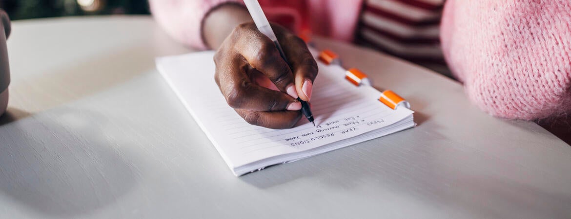 Woman writing her New Year's resolutions