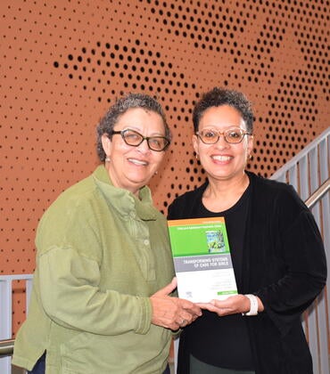 Michelle Porche and Lisa Fortuna hold a book