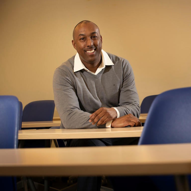 Eddie Comeaux sits in en empty lecture hall