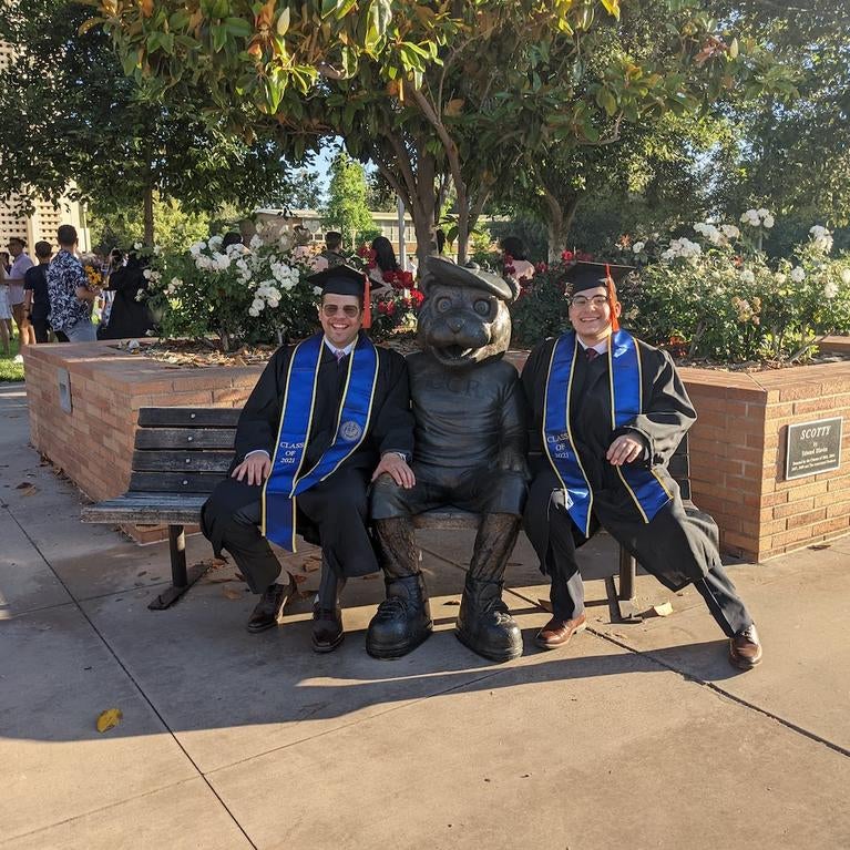 Mahmood Shaheen and Nathaniel Ortiz sit with Scotty before a commencement ceremony