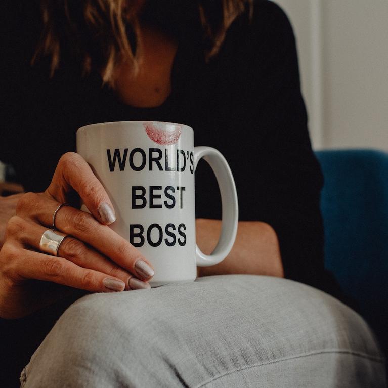 A woman holding a mug that says World's Best Boss