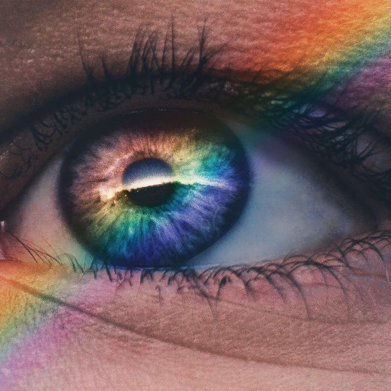 A rainbow falls across a person's eye