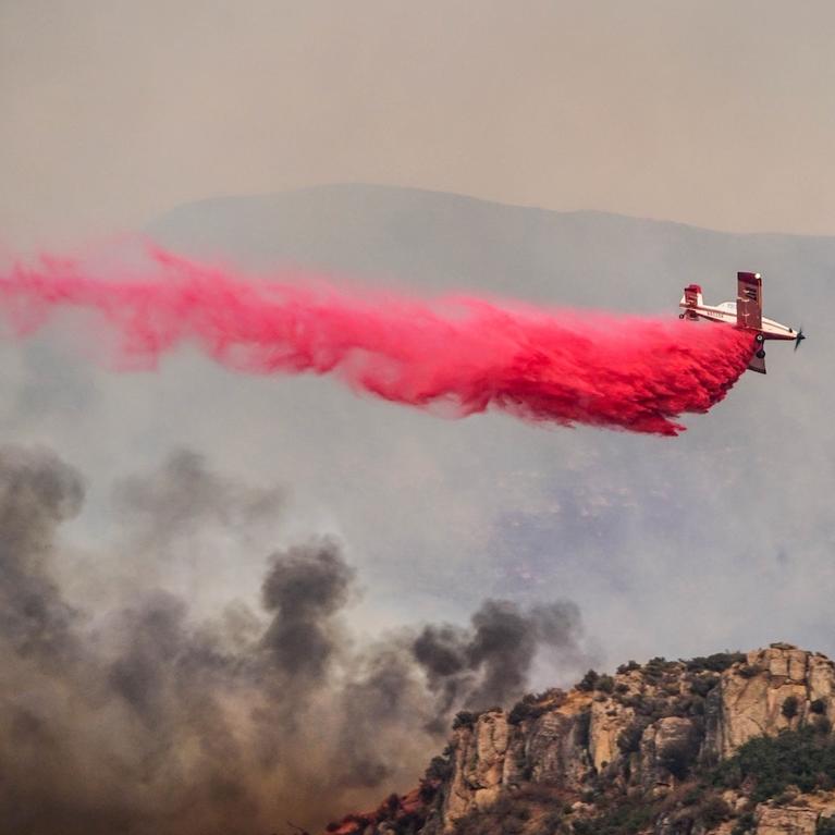 A plane drops pink fire retardant on a wildfire in Utah