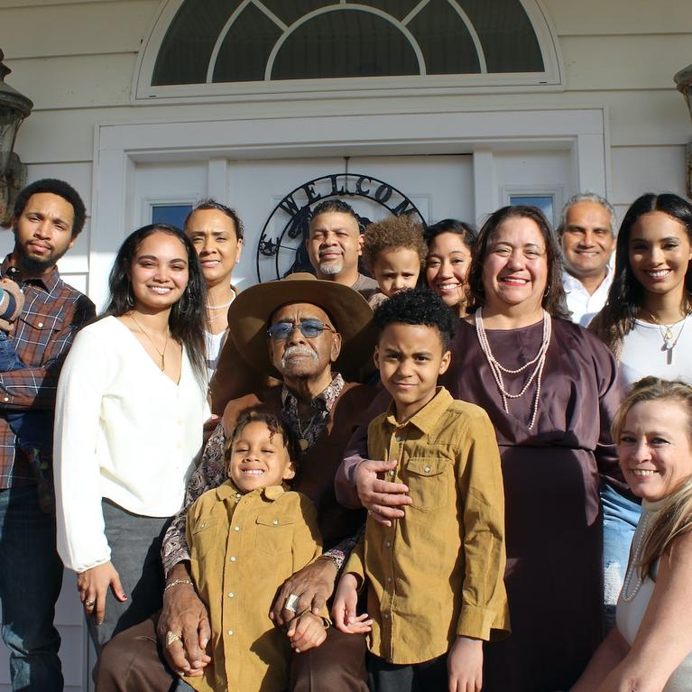 A family stands in front of a house