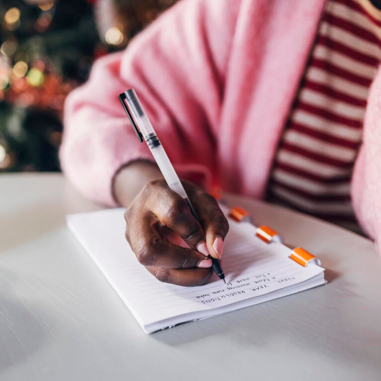 Woman writing her New Year's resolutions
