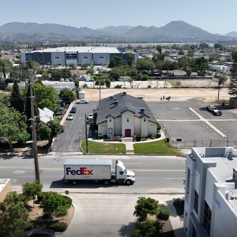 Built in 1928, St. Mark’s Missionary Baptist Church is now surrounded by warehouses. (Aerial footage of Valley Truck Farms by Tamara Cedré and Adrian Metoyer III, 2024, courtesy of the artists and A People’s History of the I.E.)