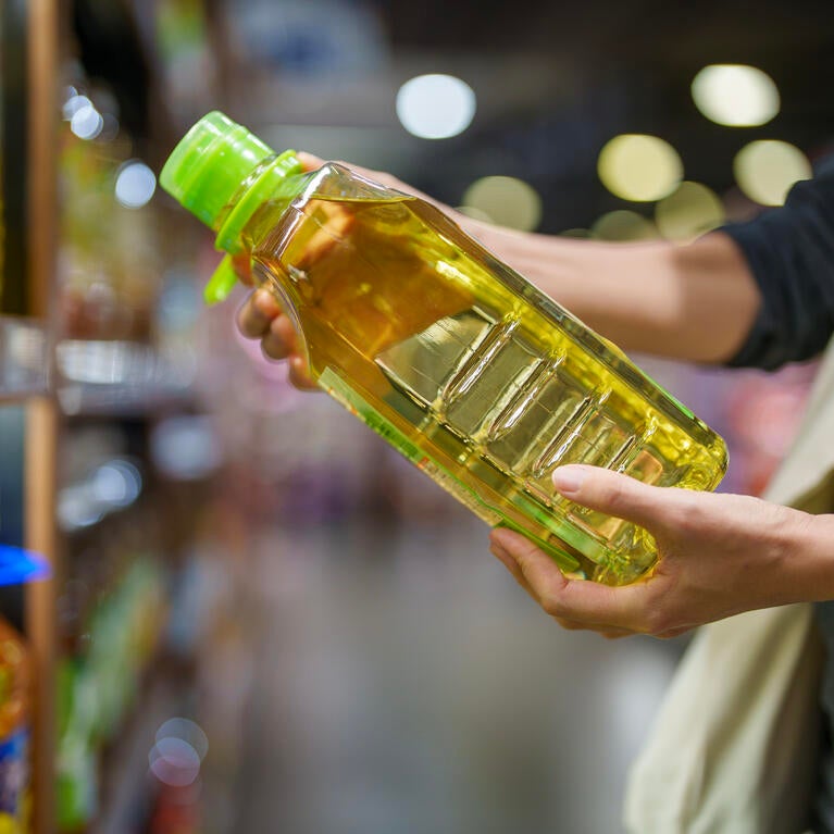 shopper holding bottle of oil