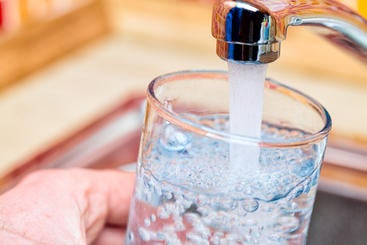 A picture of someone filling a glass with tap water