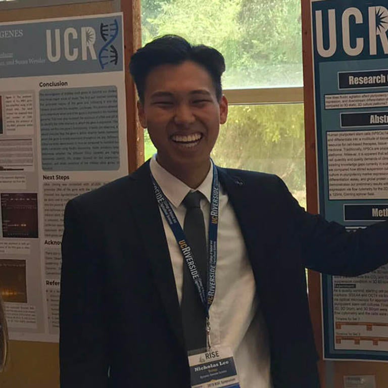 RISE participant in front of research poster