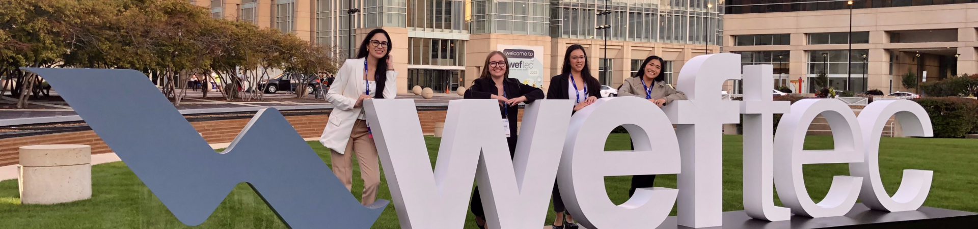 Senior Design Team at WEFTEC standing by sign