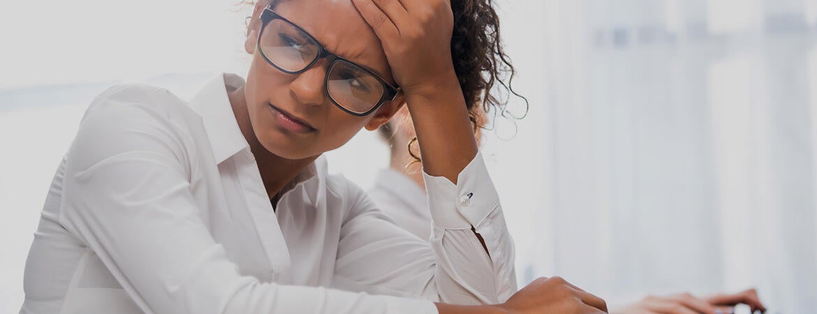 student looking stressed while sitting at a desk 
