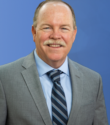 Tim Collins in front of a globe