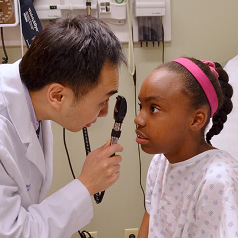 Medical student looking at a child in the eye