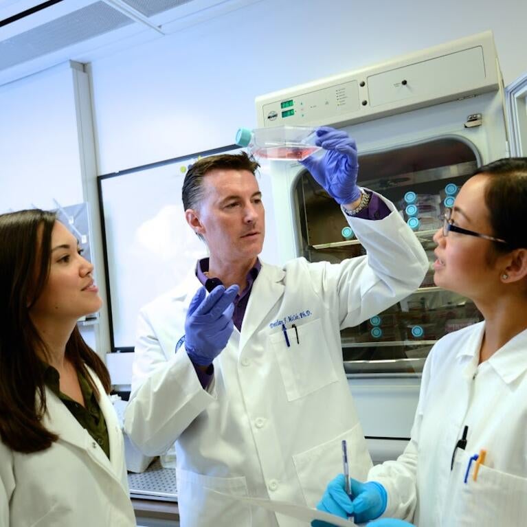 Declan McCole in the lab with two graduate students