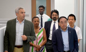 Vladimir Oge walking with Chancellor Hu and other senior leaders