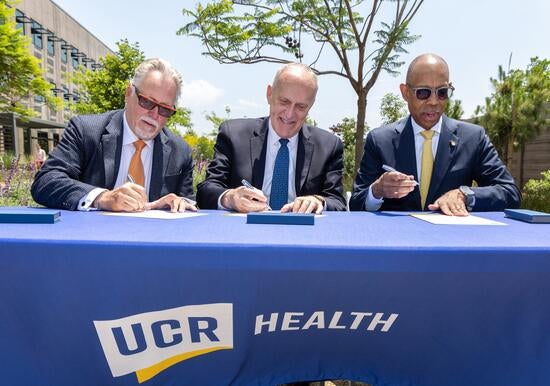 Garry Spanner, president of Canyon Springs Marketplace Corp, UCR Chancellor Kim Wilcox, and UC President Michael V. Drake sign a letter of intent. by Stan Lim