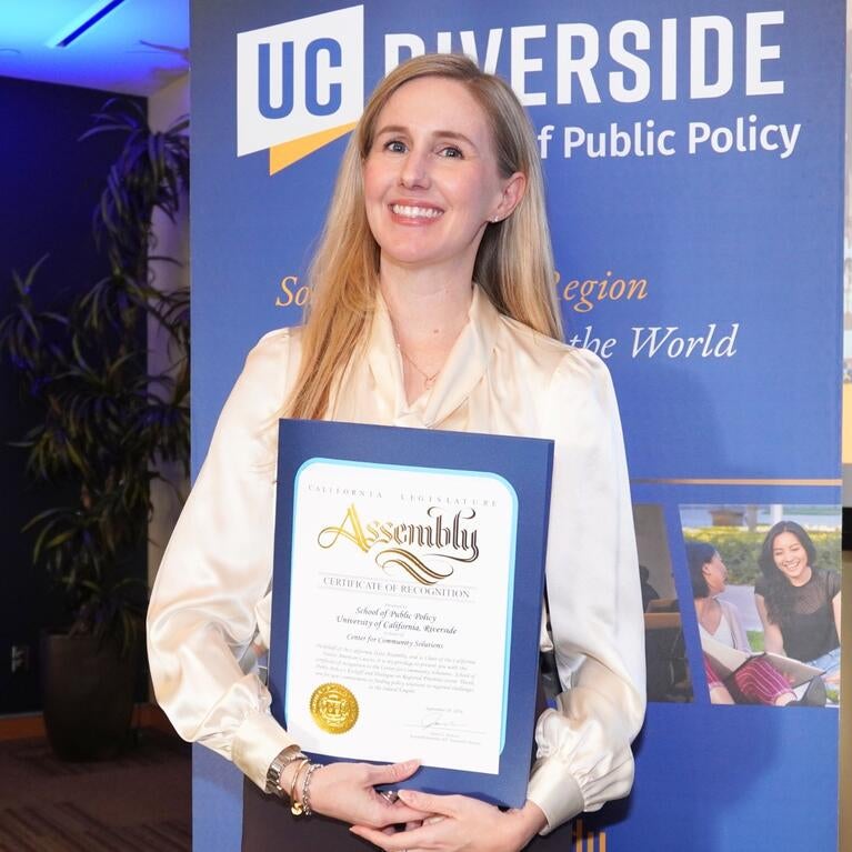 Justine Ross holding the certificate for the new research center
