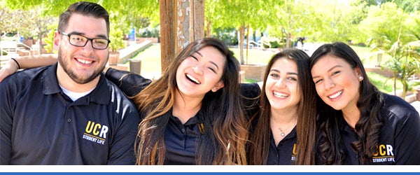 A group of students who work in the Student Life office pose in their staff polos.