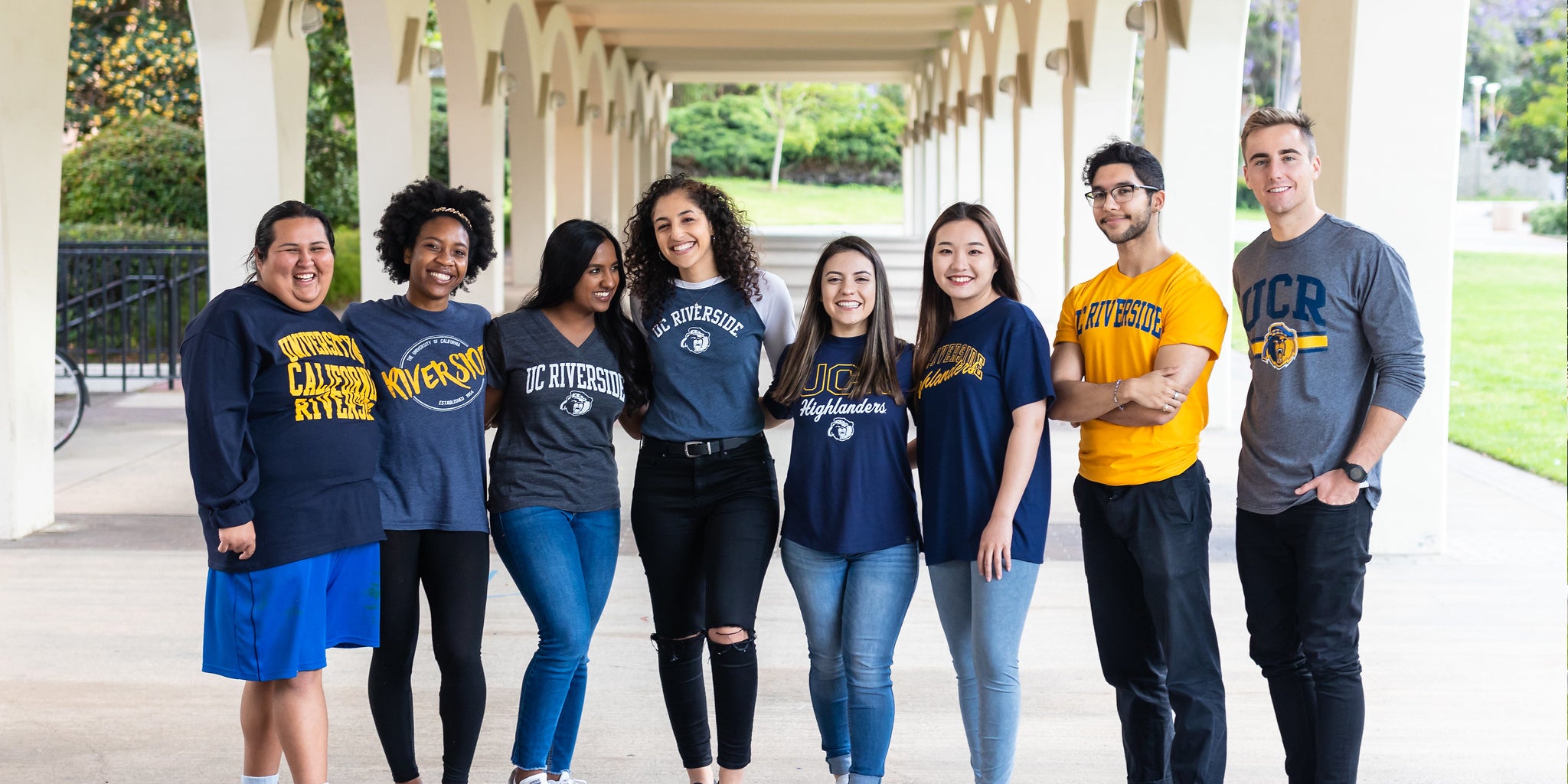 A group of UCR students pose in front of the Rivera Library.