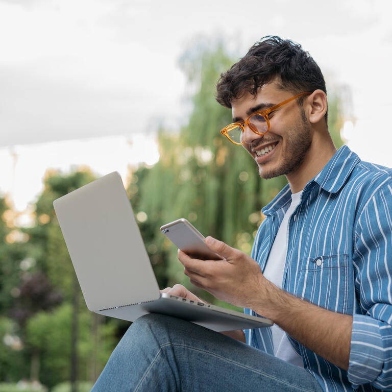 Man using computer and phone to place a call