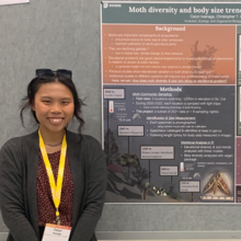 Woman next to scientific poster 