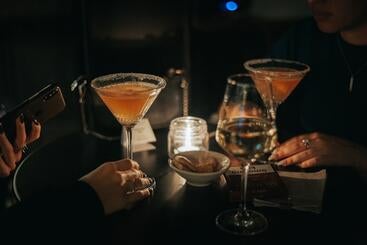Martini glasses in a dark room lit by a candle