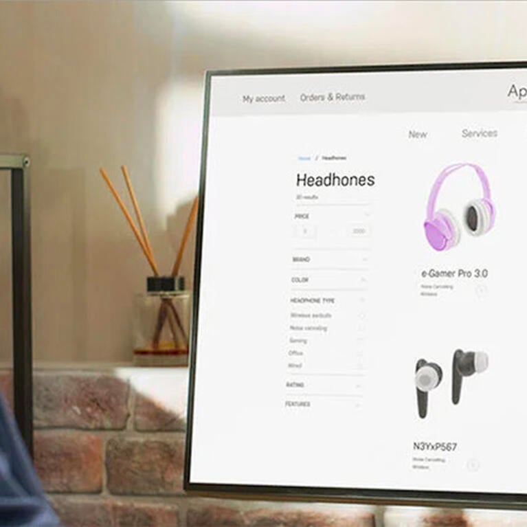 Male consumer looking at computer screen with headphones