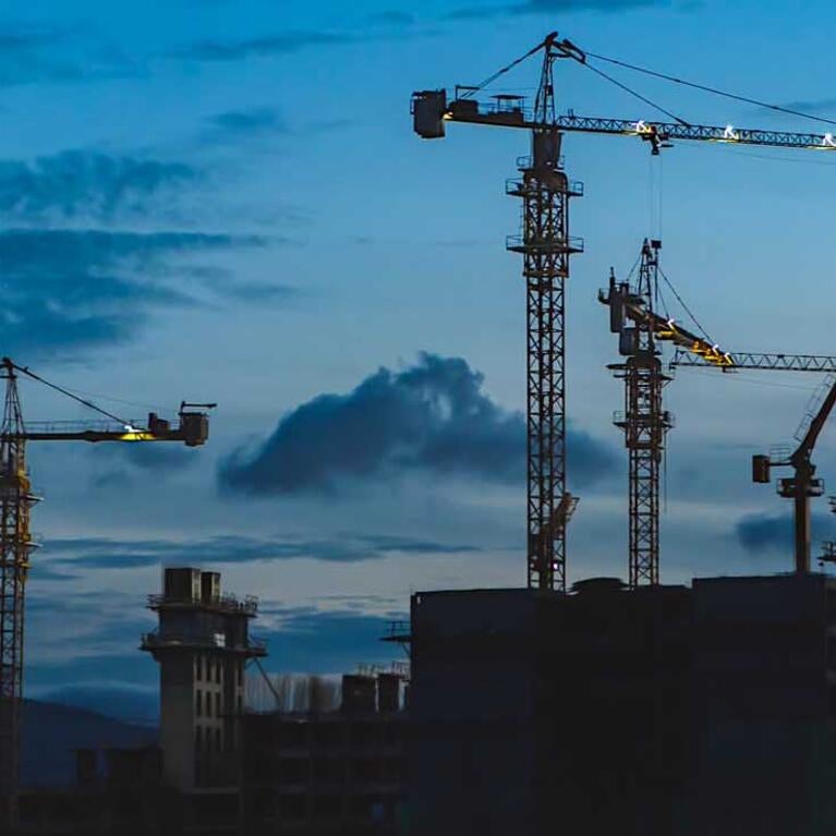 Construction site with cranes after dark in California