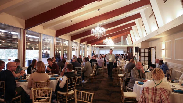 Conference attendees seated at round tables during the evening networking banquet at Canyon Crest Country Club, Riverside, CA.