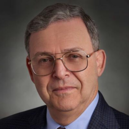 profile of man with gray hair and glasses wearing suit