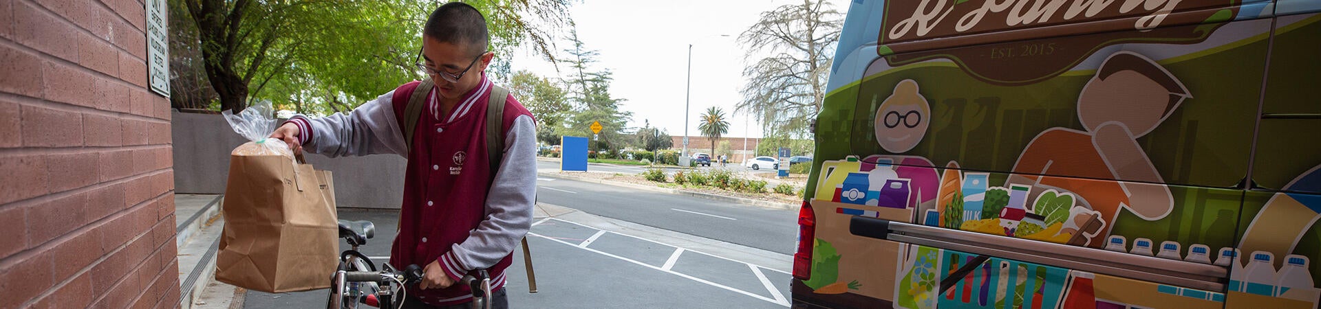 UCR student receives a bag of groceries from R'Pantry