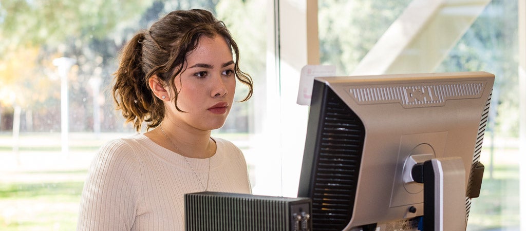A UCR student uses one of the workstations in the Highlander One-Stop Shop (HOSS).