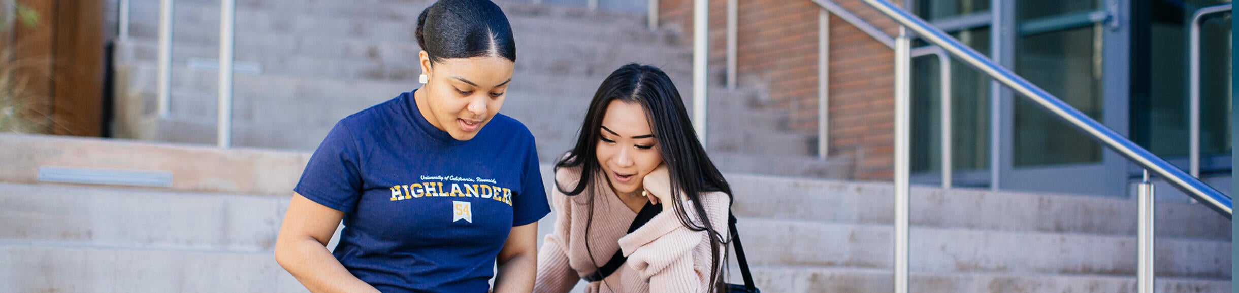 Students On Steps Looking at a Laptop