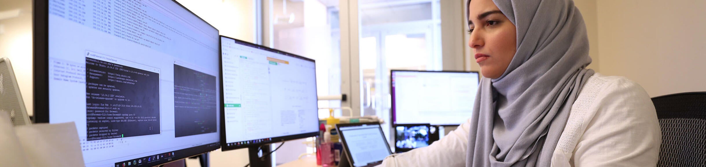 student working on multiple computer screens