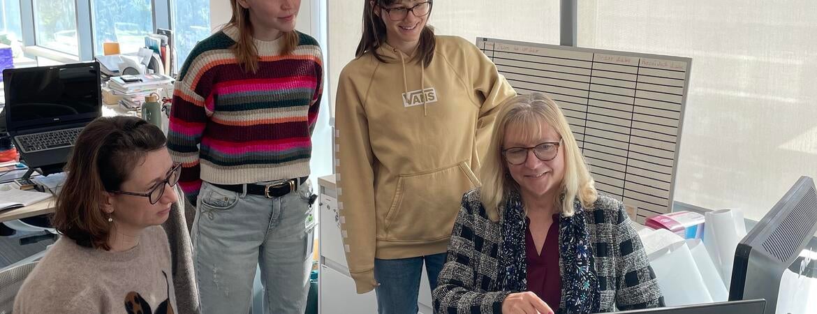 Dr. Iryna Ethell sitting at a computer surrounded by students