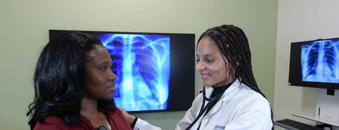 student checking the heart of a patient