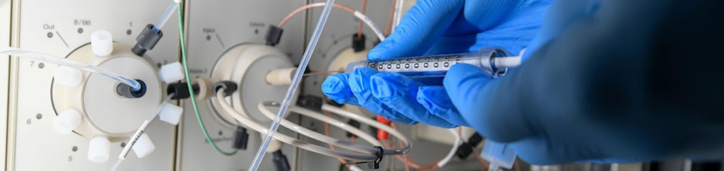 Syringe injecting into a port on a machine