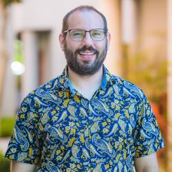 Shane O'Brien, Training Coordinator & Learning Systems Analyst at UC Riverside, in a blue and yellow button up shirt smiling for headshot