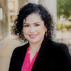 Yazil Navarro, formerly part of UC Merced, wearing a pink blouse with a black blazer, smiling for headshot