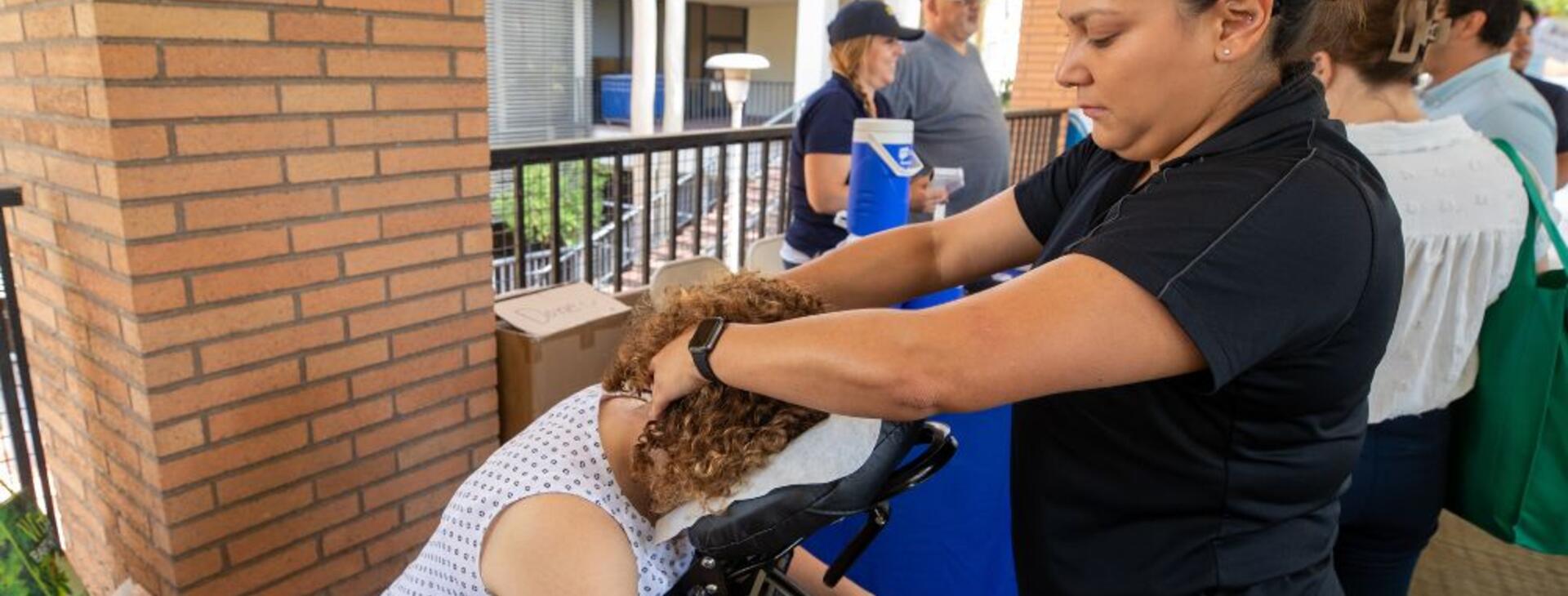 A UCR employee receiving a free chair massage from the Student Recreation Center at the 2022 Community Partner Fair
