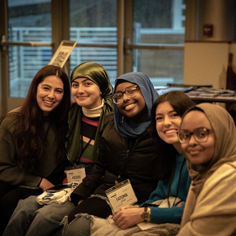 group of five girls sitting on a couch