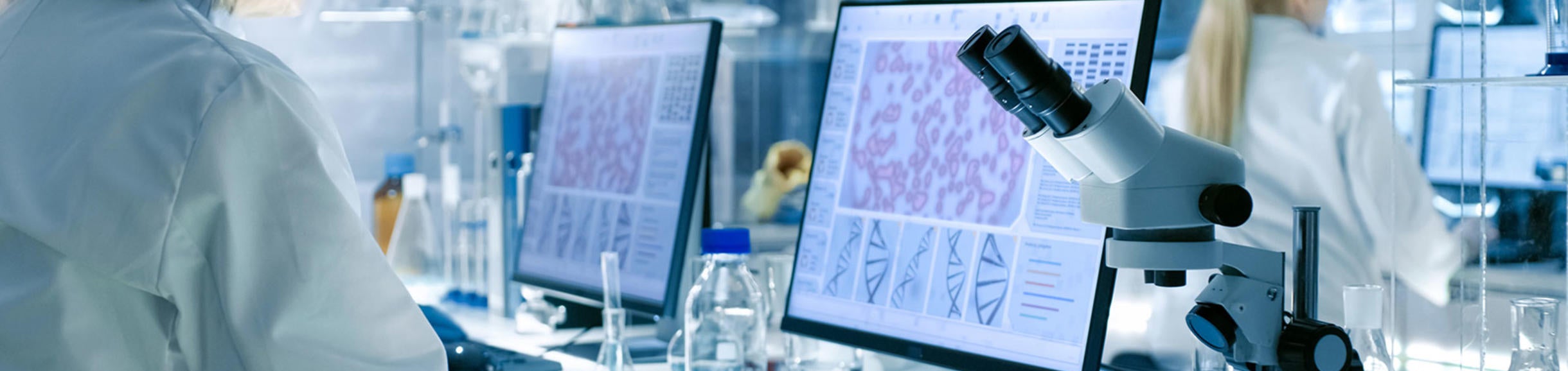 microscope, beakers and computer screens in the lab (c) iStock