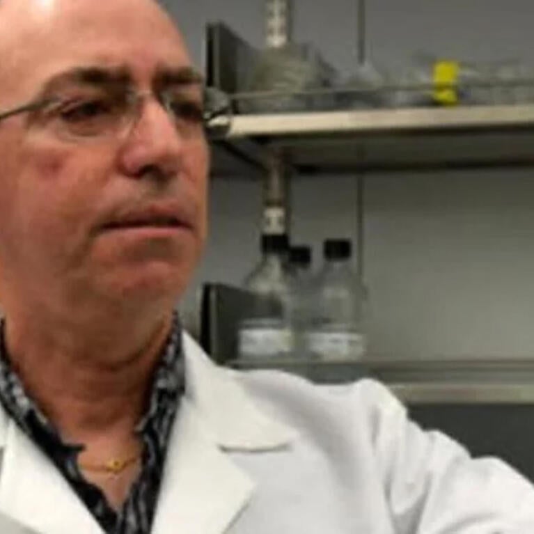 Ernest Martinez looking at petri dish in his lab
