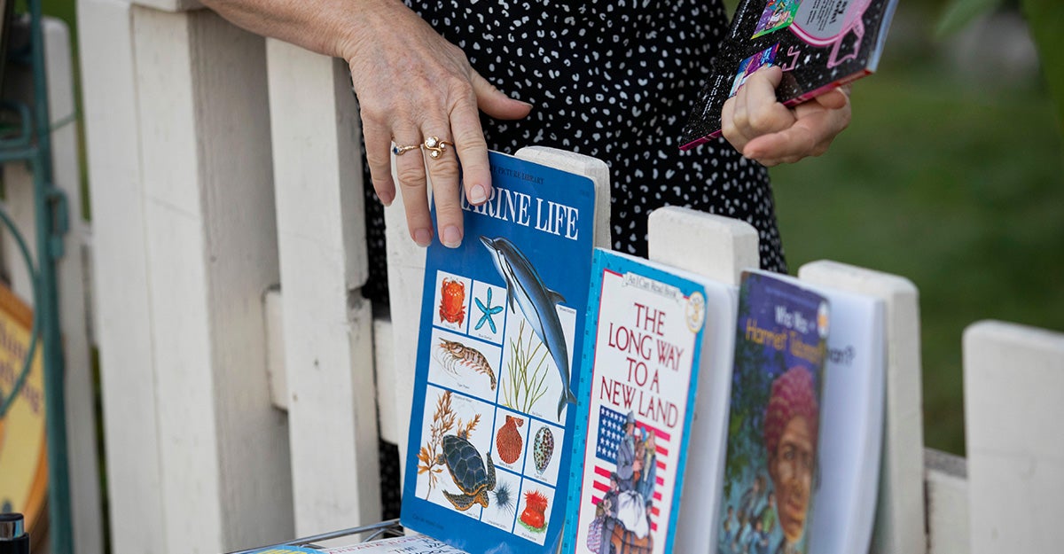 Photo of library books leaning against a fence