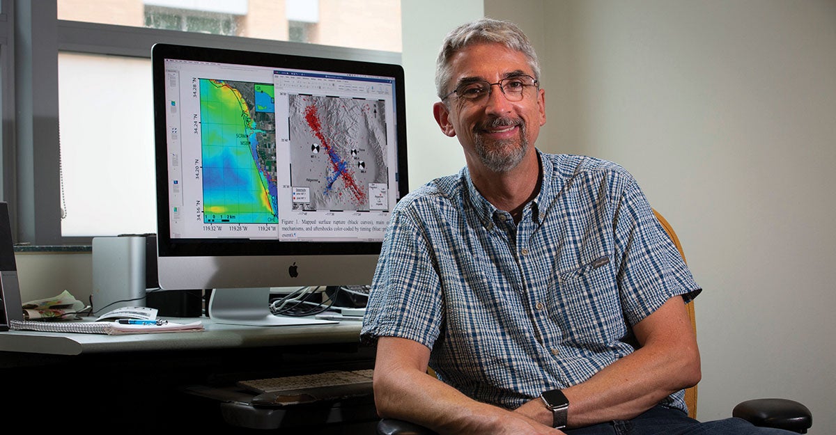 Photo of Oglesby in front of his computer monitor showing fault lines